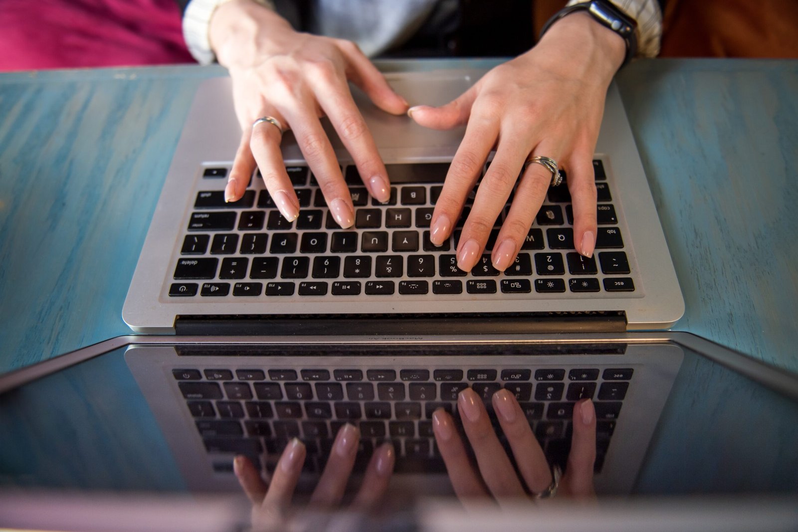 a high angle view of woman typing on laptop - best ai paraphrasing tool