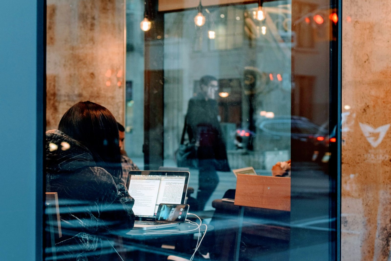 woman working on her assignment by the window - best paraphrasing tool for students