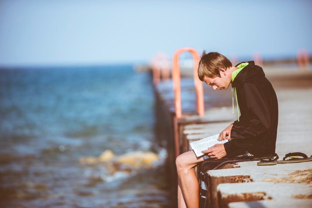 student reading a book by the sea - unique argumentative essay topics