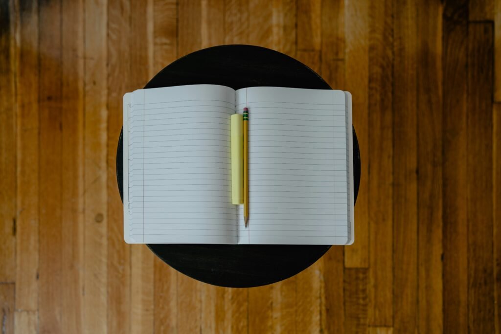 a notebook with pencil on the top - How to Write a Good Hook for an Essay