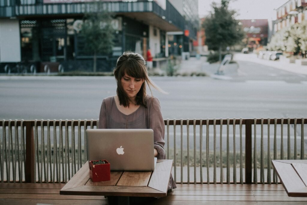 girl sitting on a roadside and using laptop - SAT Reading And Writing
