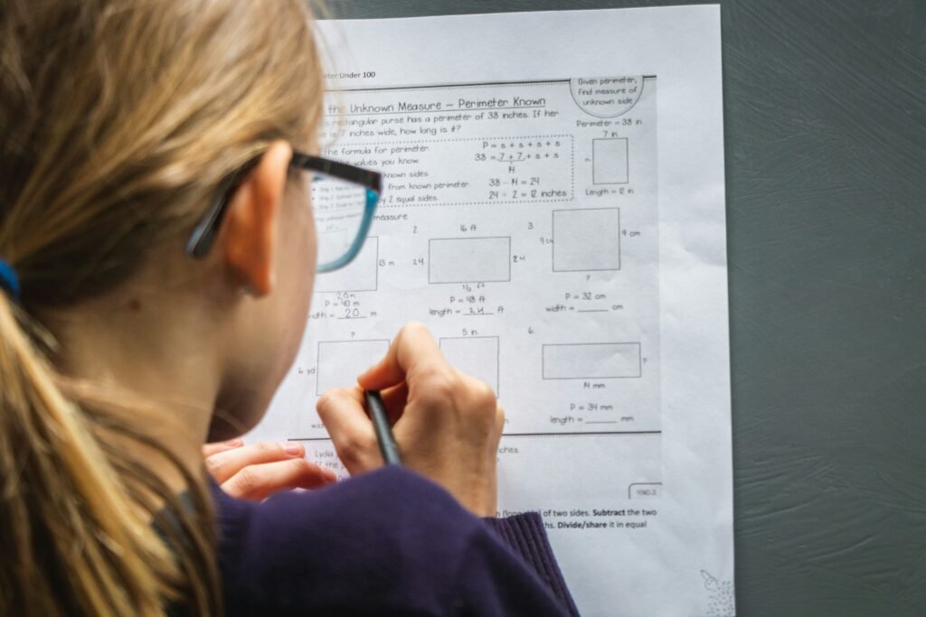 girl solving a math paper - SAT Math Topics
