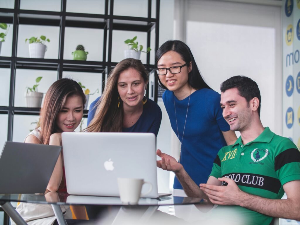 4 People Looking at the Laptop placed on the Table - Best SAT Prep App