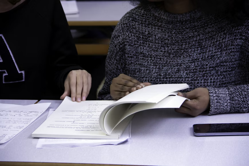 students with a book - Why I Deserve This Scholarship Essay