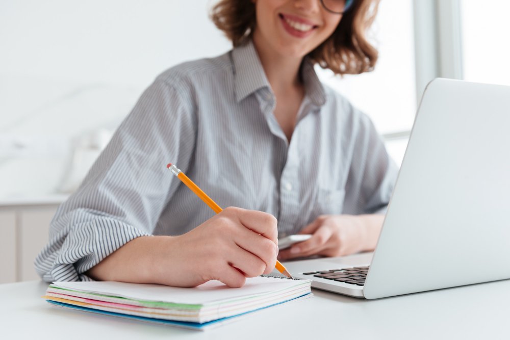 woman smiling and writing - Diversity Essay Examples
