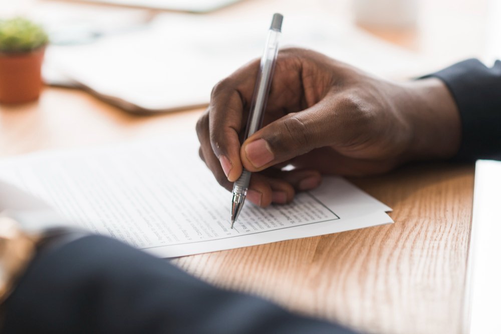 man writing with a pen - Evaluation Essay Examples